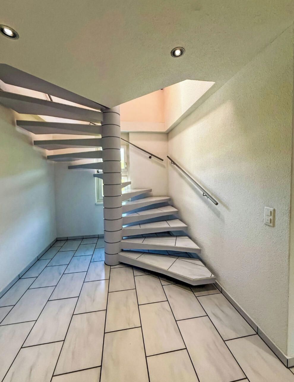 Eine moderne Treppe mit außergewöhnlichem Design, die zu einer oberen Etage führt.
