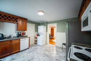 A kitchen with wooden cabinets, a white refrigerator, a stove, and a microwave.