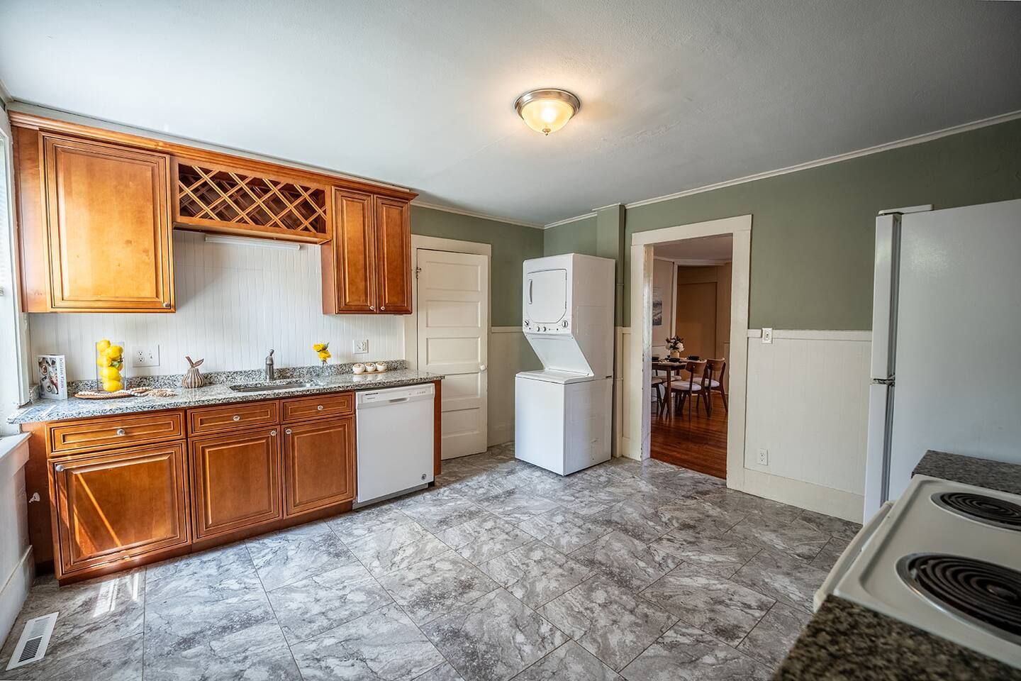 Una cocina con armarios de madera, lavavajillas, refrigerador y estufa.