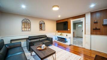Una sala moderna con sofá, mesa de centro y chimenea.