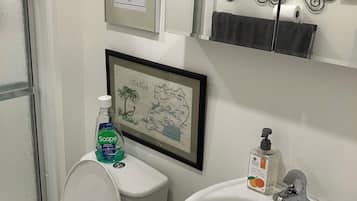 Un baño con inodoro, lavabo y un mapa enmarcado de Uganda.