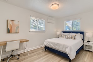 A bedroom with a bed, bedside tables, a desk, and a chair. - Comfy 2-bedroom townhome in East Austin. Huge back yard! (Austin)