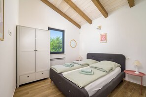 A bedroom with a bed, a wardrobe, a window, a mirror, a bedside table, and a lamp. - Villa Sonnenschein (Istria - Svetvinčenat) (Svetvinčenat)