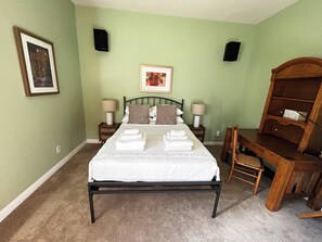 A bedroom with a bed, two bedside tables, a chair, a desk, and a bookshelf. - Ponderosa Pine Getaway in the Boulder Foothills (Boulder)