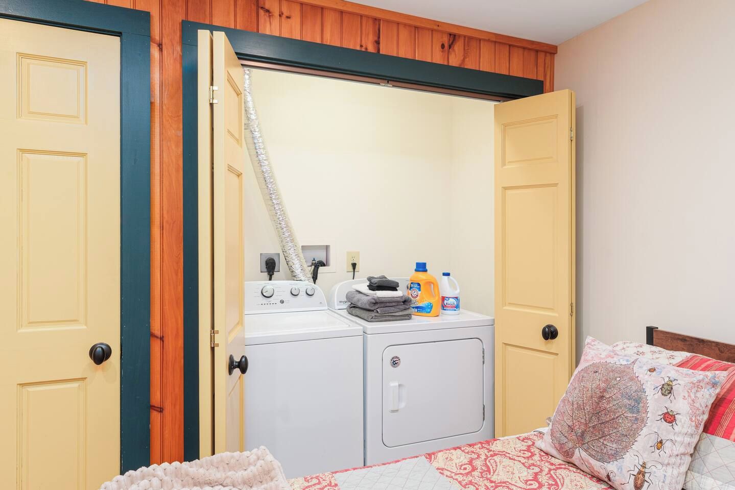 A laundry room with a washing machine and dryer, a drying rack, and laundry supplies.