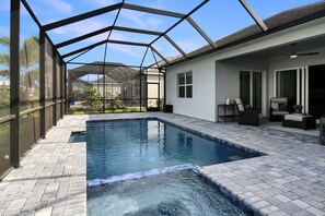 A swimming pool with a glass ceiling, surrounded by a patio area with outdoor furniture. - Pool Home In Calusa Golf & Country Club - Fore Seasons (Bradenton)