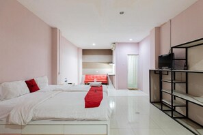 A hotel room with two beds, a TV, and a minibar. - Reddoorz @ Siwalankerto Surabaya (Surabaya)