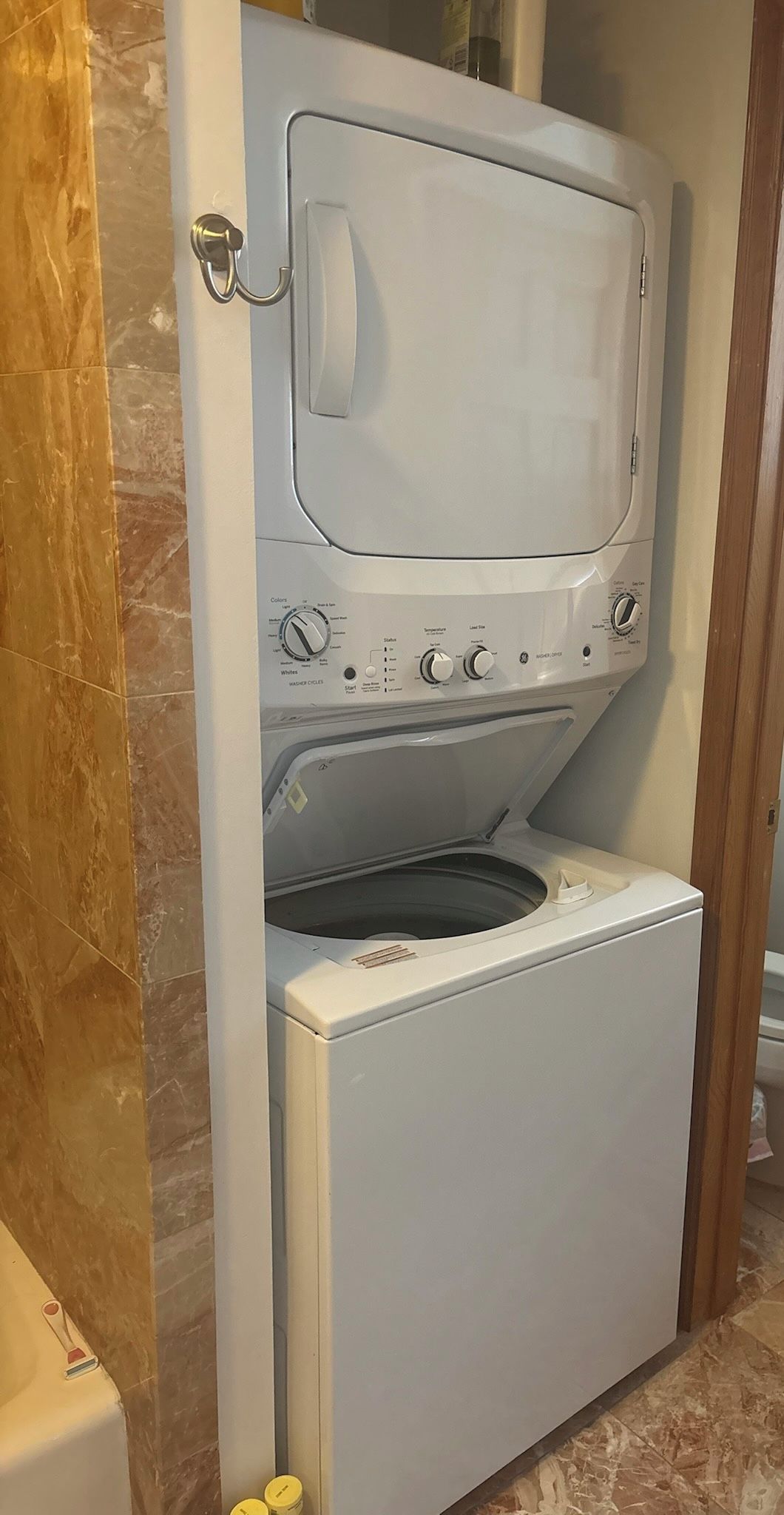 En lille, hvid vaskemaskine med frontåbning og et kontrolpanel med flere knapper og drejeknapper.
