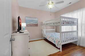 A child's bedroom with bunk beds, a desk with a computer and lamp, and a ceiling fan. - 4BR w/ Pool / Hot Tub / Firepit / Sleeps 10 (Newport)