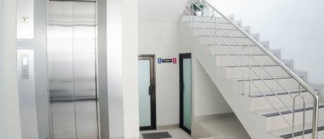 Een lift, een trap en een bordje met daarop een toilet.