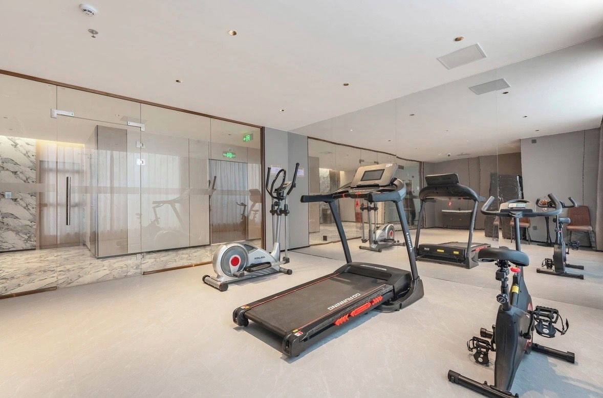 Un gimnasio moderno con cintas de correr, bicicletas estáticas y elípticas.
