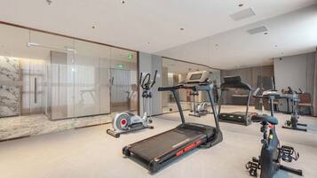 Un gimnasio moderno con cintas de correr, bicicletas estáticas y elípticas.