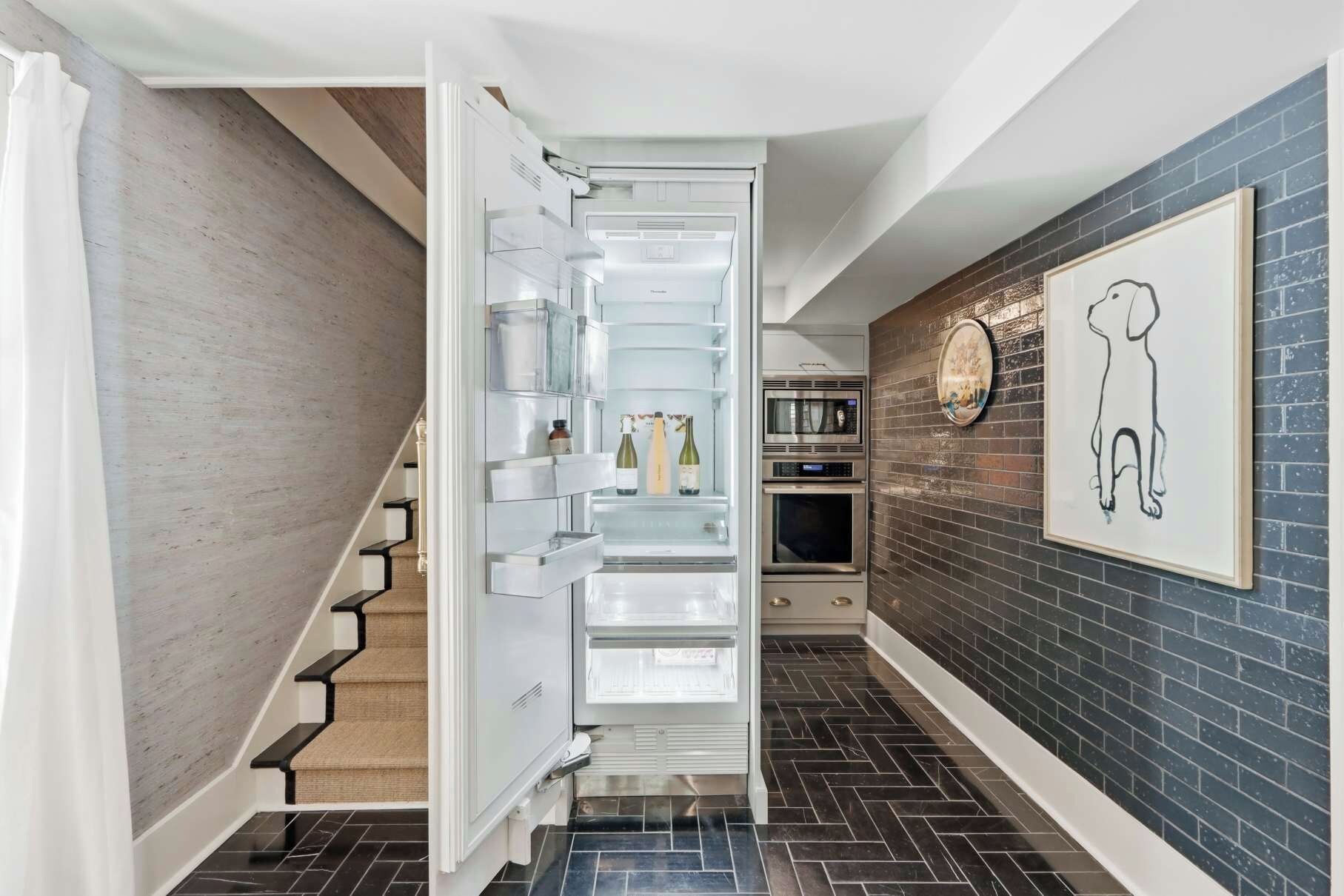 A modern kitchen with a built-in refrigerator, a microwave, and a stove.