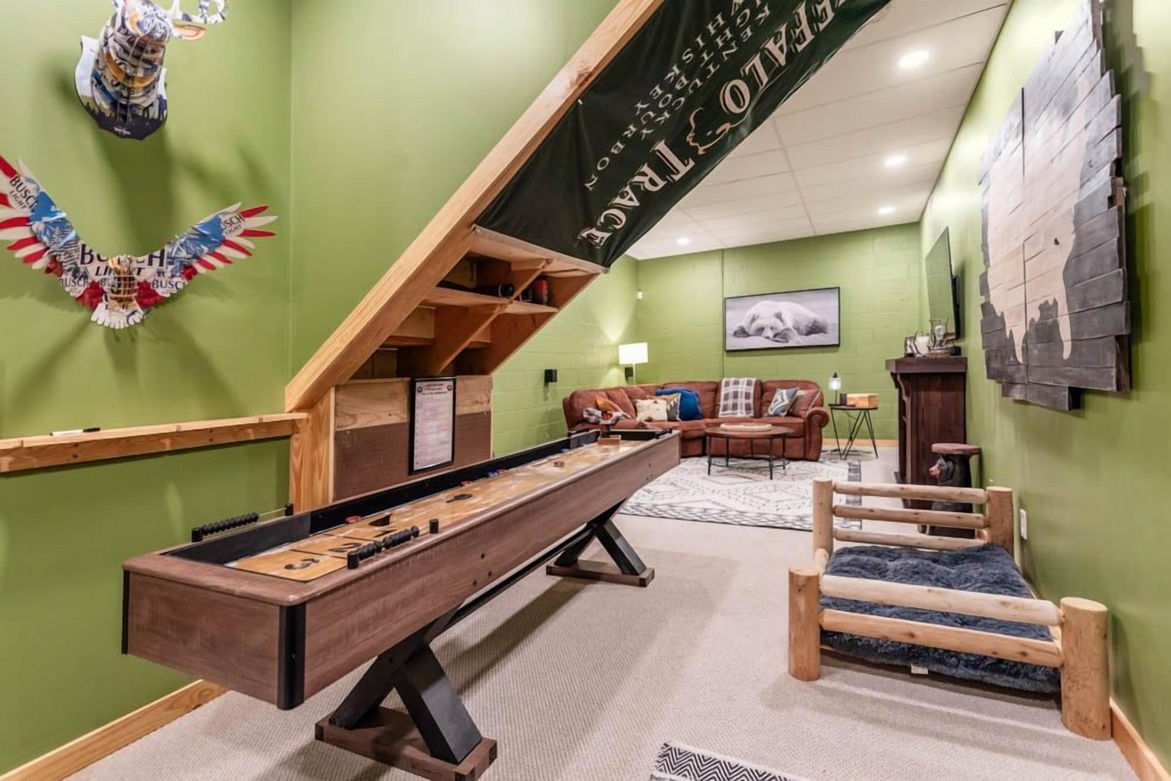Une pièce avec une table de baby-foot, un canapé, un lit et une banderole accrochée au mur.