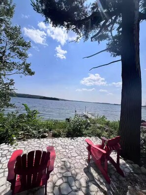 A view of a lake with chairs and a tree. - The Lake House at Moira | 270° Lake Views, Hot Tub, Game Room & Sport Court (Centre Hastings)