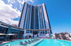 A high-rise hotel with a swimming pool and sun loungers. - Modern Sabana Retreat - Fast Wifi, Pool, Gym (San José)