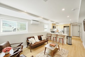 A modern apartment with a living room, kitchen, and dining area.