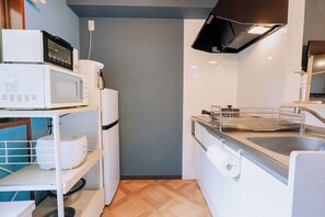 A compact kitchen with a microwave, a small refrigerator, a sink, and a stove. - Family-Friendly Home｜5min to USJ｜Near Nishikujo (Osaka)