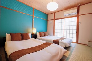 A hotel room with two beds, a window, an air conditioning unit, and a lamp. - Family-Friendly Home｜5min to USJ｜Near Nishikujo (Osaka)