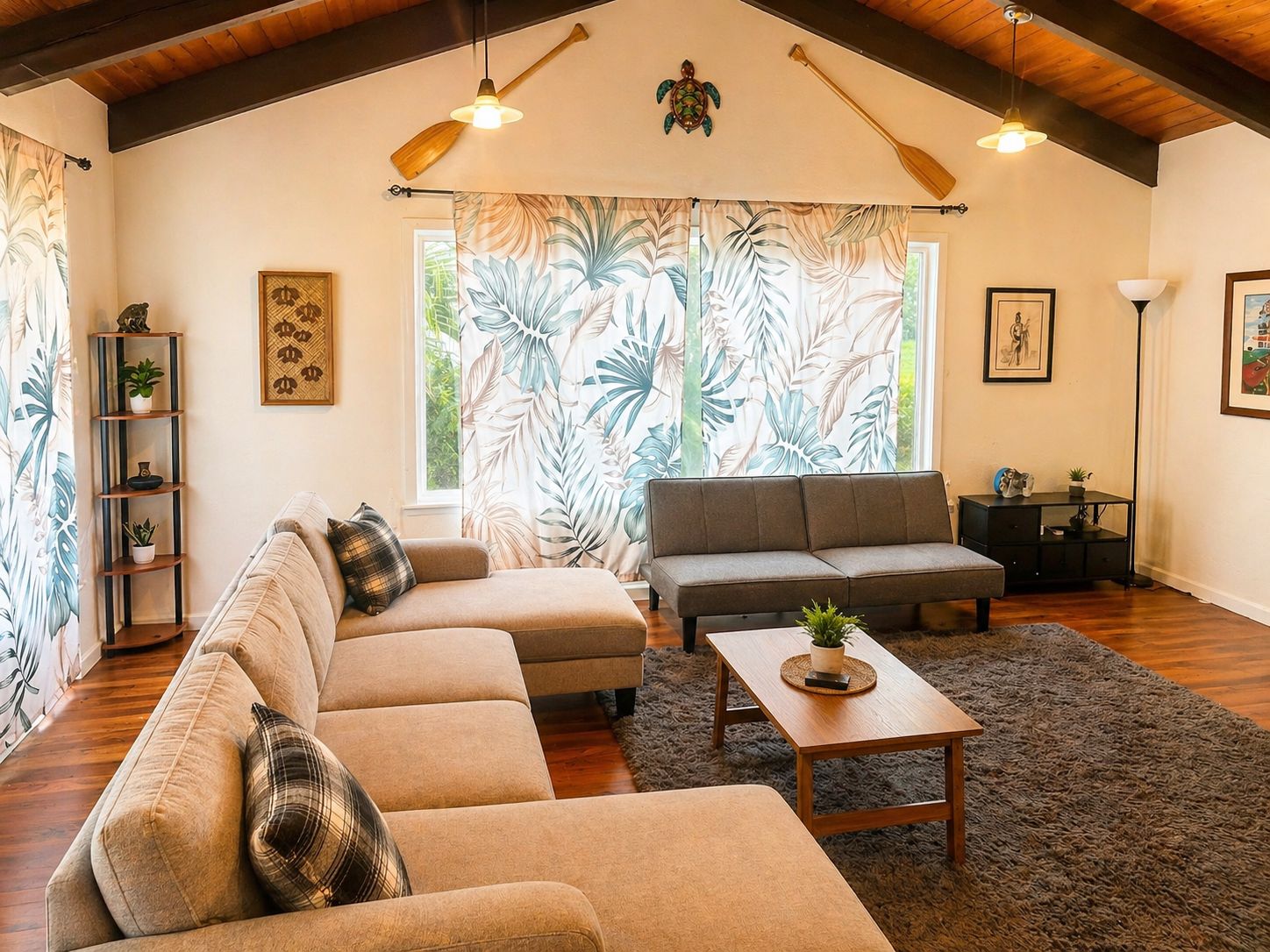 A living room with a sofa, a loveseat, a coffee table, and a bookshelf. There are two ceiling fans, a window with curtains, and a floor lamp.