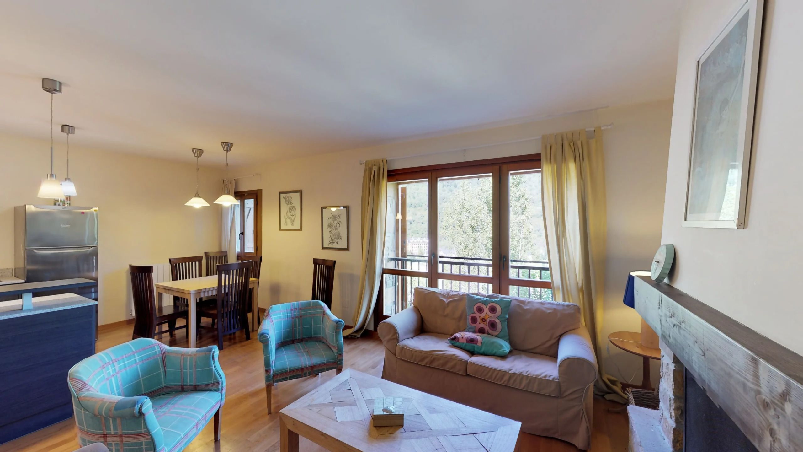 A living room with a sofa, chairs, a dining table, and a kitchen area.