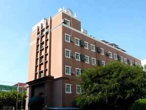 A multi-story building with a flat roof, rectangular windows, and a central entrance.