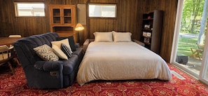 Une chambre à coucher avec un grand lit, un canapé, une armoire en bois et une bibliothèque.