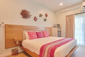 A bedroom with a wooden headboard, a bed with white and pink bedding, decorative wall art, a small bedside table, and a window with curtains. - Suite in La Punta, a minute from the sand (Puerto Escondido)
