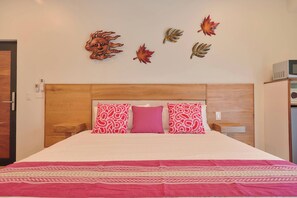 A hotel room with a wooden headboard, a bed with a white and red patterned bedspread, and decorative wall art. - Suite in La Punta, a minute from the sand (Puerto Escondido)