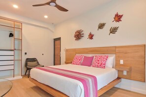 A bedroom with a bed, a chair, a wardrobe, and a ceiling fan. - Suite in La Punta, a minute from the sand (Puerto Escondido)