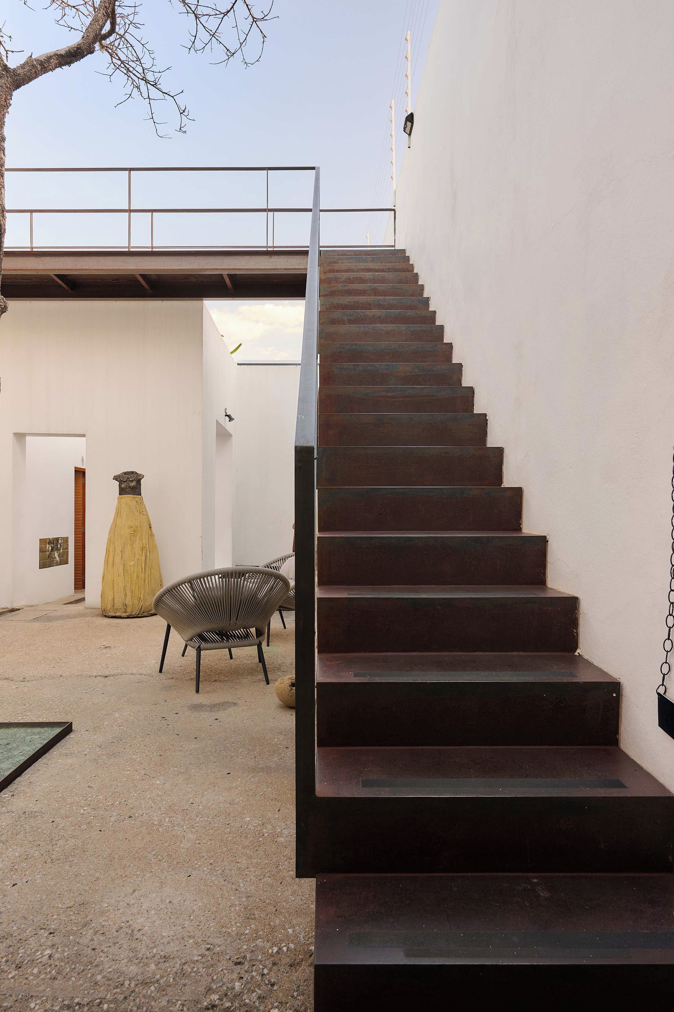 A staircase leading to an upper level, with a railing on the outside.