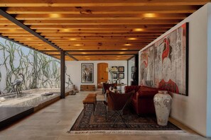 A spacious room with a wooden ceiling, a large painting, a dining area, and a water feature. - Artistic Oasis in Oaxaca's Historic Center (Oaxaca de Juárez)