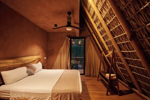 Een kamer met een bed, een plafondventilator, een raam met gordijnen en een houten constructie met hangende spullen.