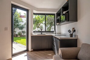 Eine moderne Küche mit einer Schiebetür aus Glas, die in einen Garten führt.