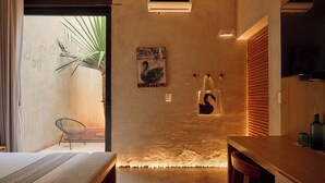 Un interno moderno con un letto, una sedia, un tavolo e un punto luce a parete.