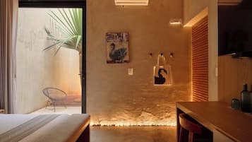 Ein modernes Interieur mit einem Bett, einem Sessel, einem Tisch und einer Wandleuchte.