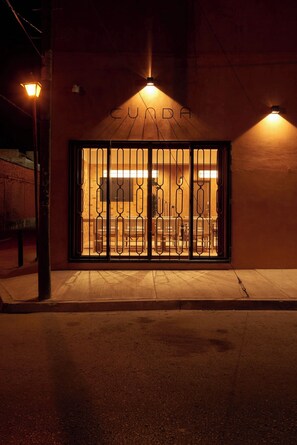 A building with a metal gate entrance, a sign above the gate, and a street lamp to the left. - Luxury Boutique Hotel Near Downtown Oaxaca (Oaxaca de Juárez)