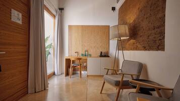 Een moderne kamer met een houten vloer, een bureau met stoel, een staande lamp en een groot raam met gordijnen.