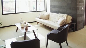 A modern living room with a sofa, a coffee table, and two chairs.