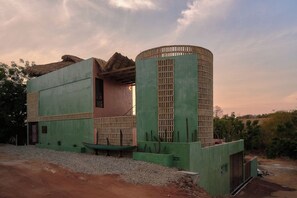 A building with a unique architectural design, featuring a large cylindrical structure and a flat-roofed section. - 5-bedroom house steps from the beach (Puerto Escondido)