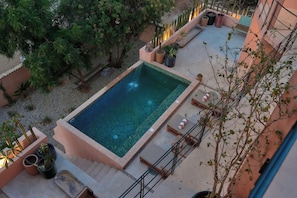 A rooftop pool with a clear blue water feature, surrounded by potted plants and outdoor furniture. - 5-bedroom house steps from the beach (Puerto Escondido)