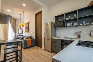 Eine moderne Küche mit Einbauofen, Kühlschrank und Essbereich mit Tisch und Stühlen.