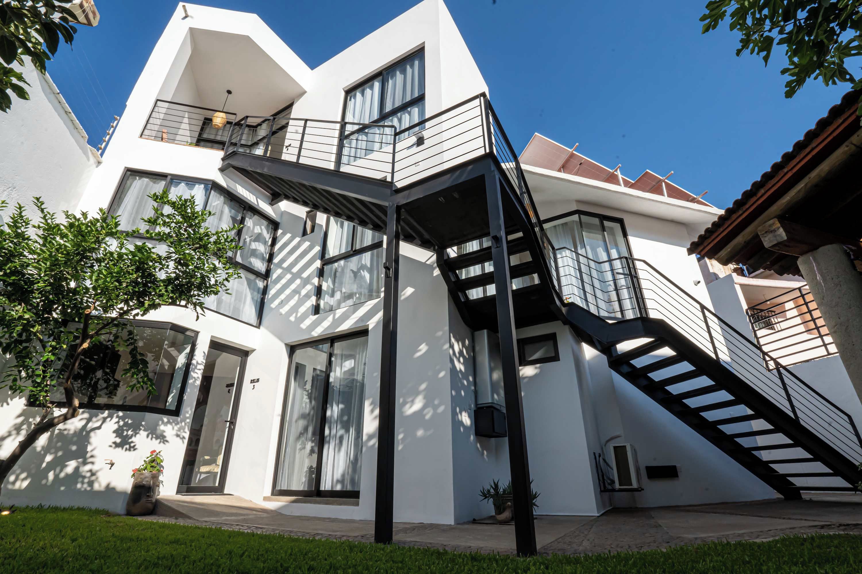 A modern two-story building with a prominent staircase and large windows.