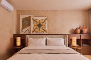 A hotel room with a bed, two wall-mounted lamps, and a shelf with pottery. - Luxury Boutique Hotel Steps from Downtown Oaxaca (Oaxaca de Juárez)