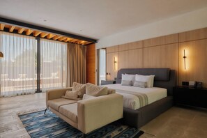 Een moderne slaapkamer met een groot bed, een slaapbank en een bureau.