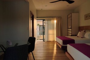 Ein Hotelzimmer mit zwei Betten, einem Schreibtisch und einem Sessel.