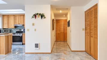 A modern kitchen with wooden cabinets, a built-in oven, and a microwave.