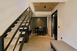 A staircase leading to a dining area with a table and chairs.