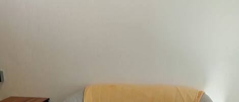 A room with a grey sofa, a small wooden table, and decorative wall art.