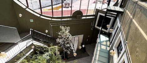 A high-rise building with a glass atrium, multiple floors, and a view of the cityscape.